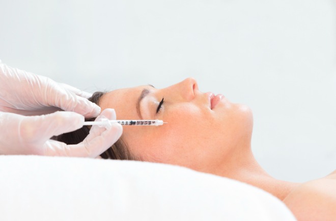 mulher em mesa de profissionar a aplicar botox em seu rosto