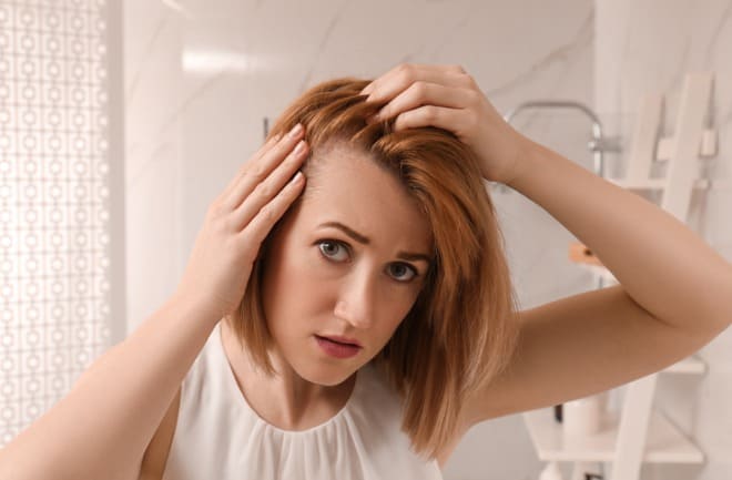 mulher verificando queda de cabelo 